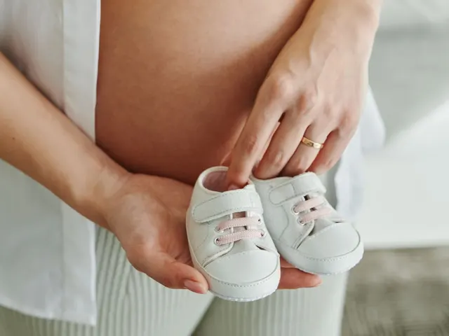 妊婦のおなかと、赤ちゃんの小さな靴