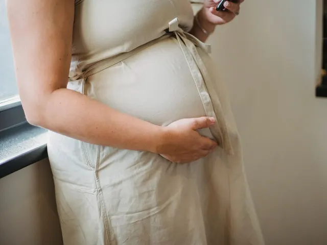 おなかに手をあてる妊婦(顔は写っていません)